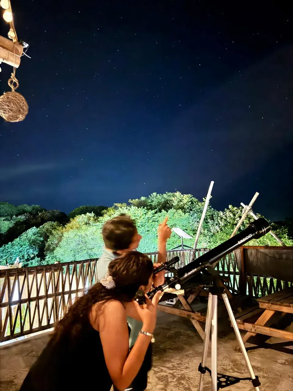 Mirando las estrellas con un telescopio en la terraza